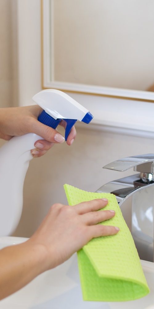 Blonde young woman cleaning bathroom